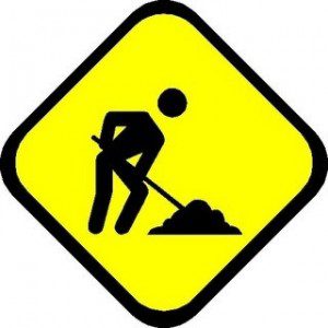 Yellow sign with stylized black outline of a figure digging