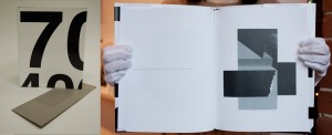 Two page spread of a photo book, black and white abstract photo on right hand page and white hard cover book with black numbers on the cover.