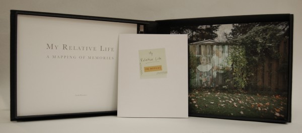 Open portfolio, title page reading My Relative LIfe , a small booklet titled My Relative Life The Archives, colour photograph of a family portrait projected on a backyard fence