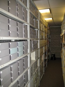 Archival boxes on shelves in Archives.