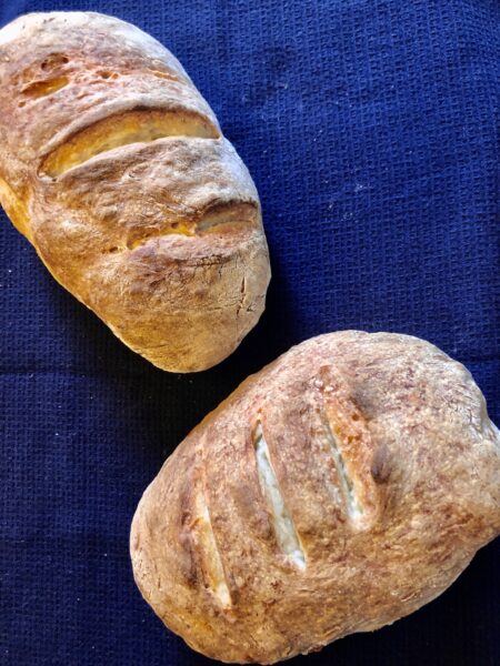 Two loaves of bread on a navy tablecloth
