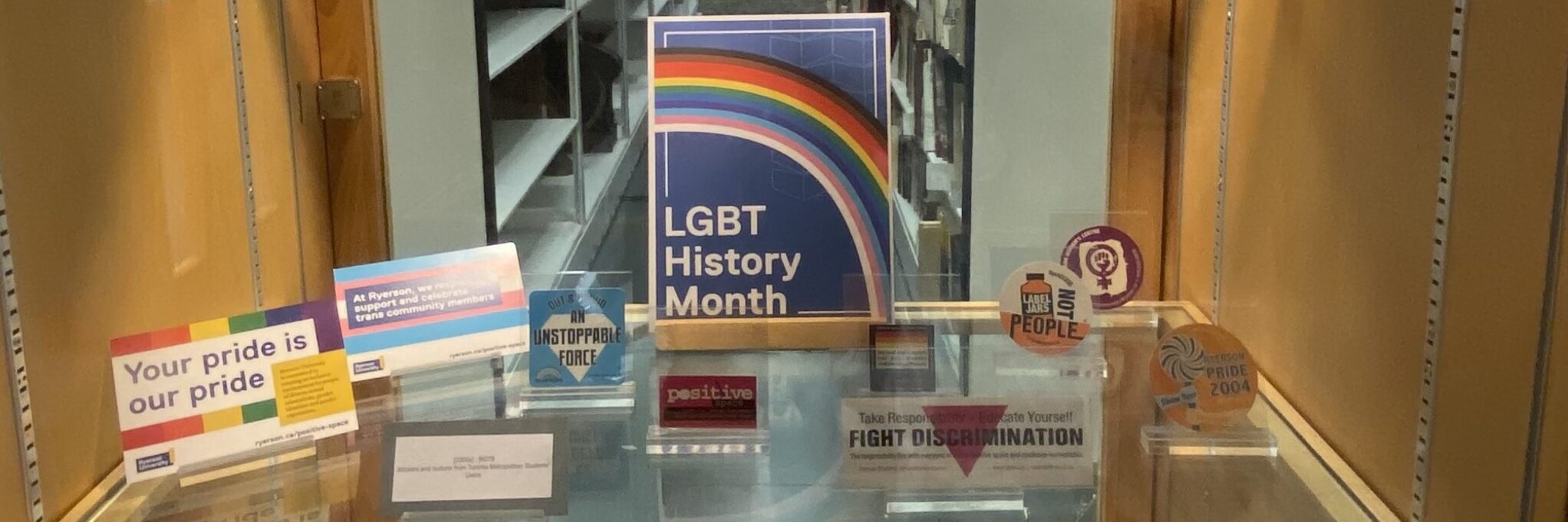 A small sign with a a rainbow and the text LGBT History Month surrounded by colourful stickers