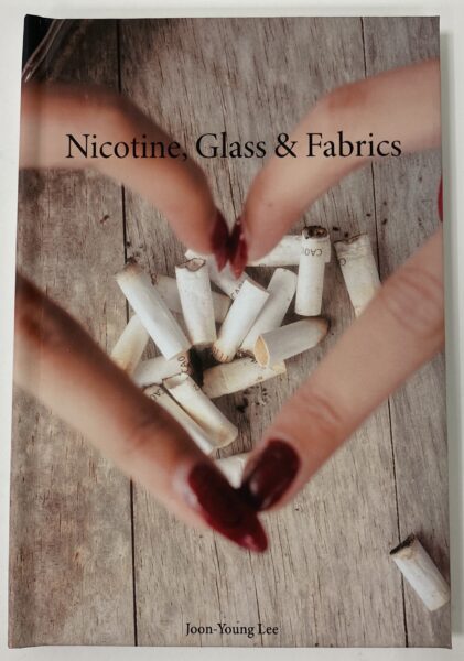 Book cover with hands making the shape of a heart over cigarettes