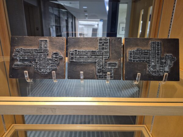 Three wood blocks with metal floor plan designs attached to them