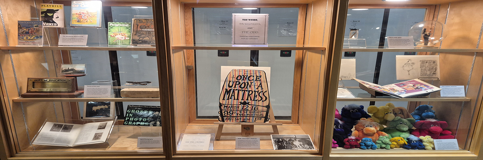 Three windows of books and objects on display