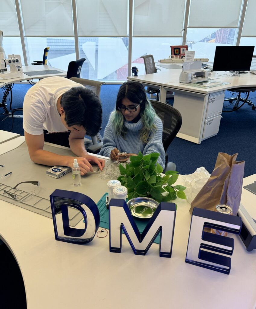 Staff and learners repairing items at DME Repair Workshop event.
