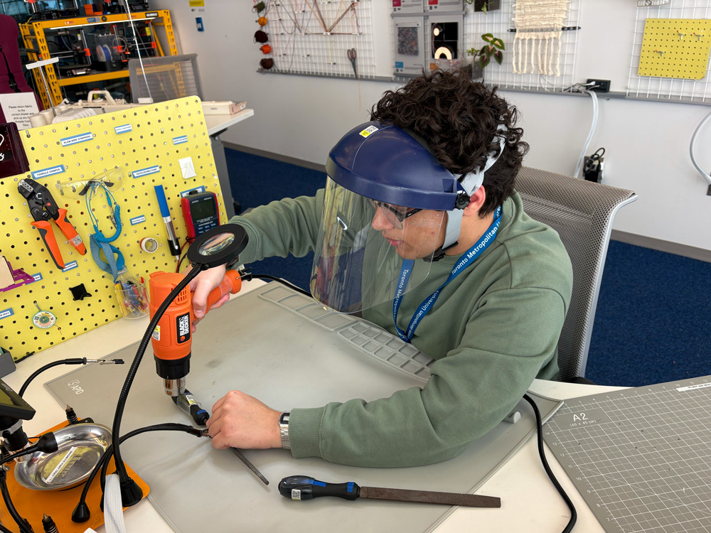 TMU student workstation operator using safety equipment