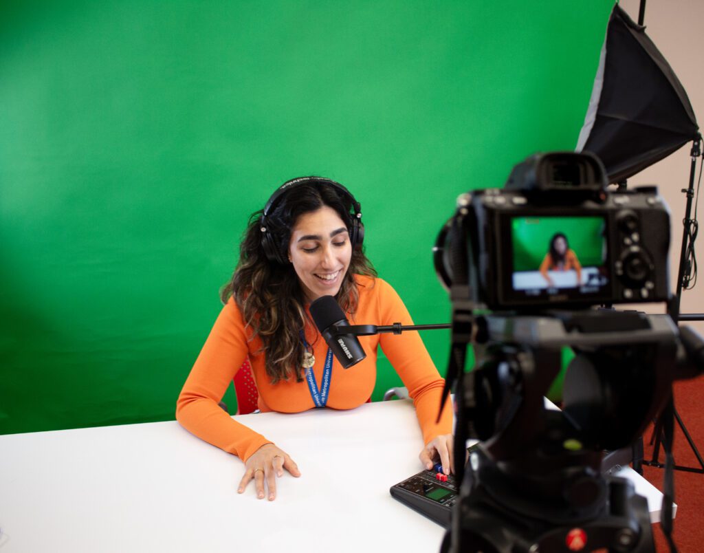 Presenter with green screen being recorded in SLC 508 studio. 