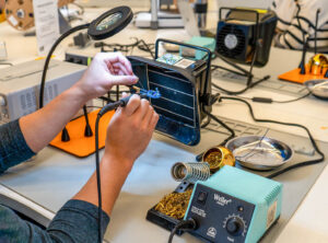 DME lab user operates soldering iron.