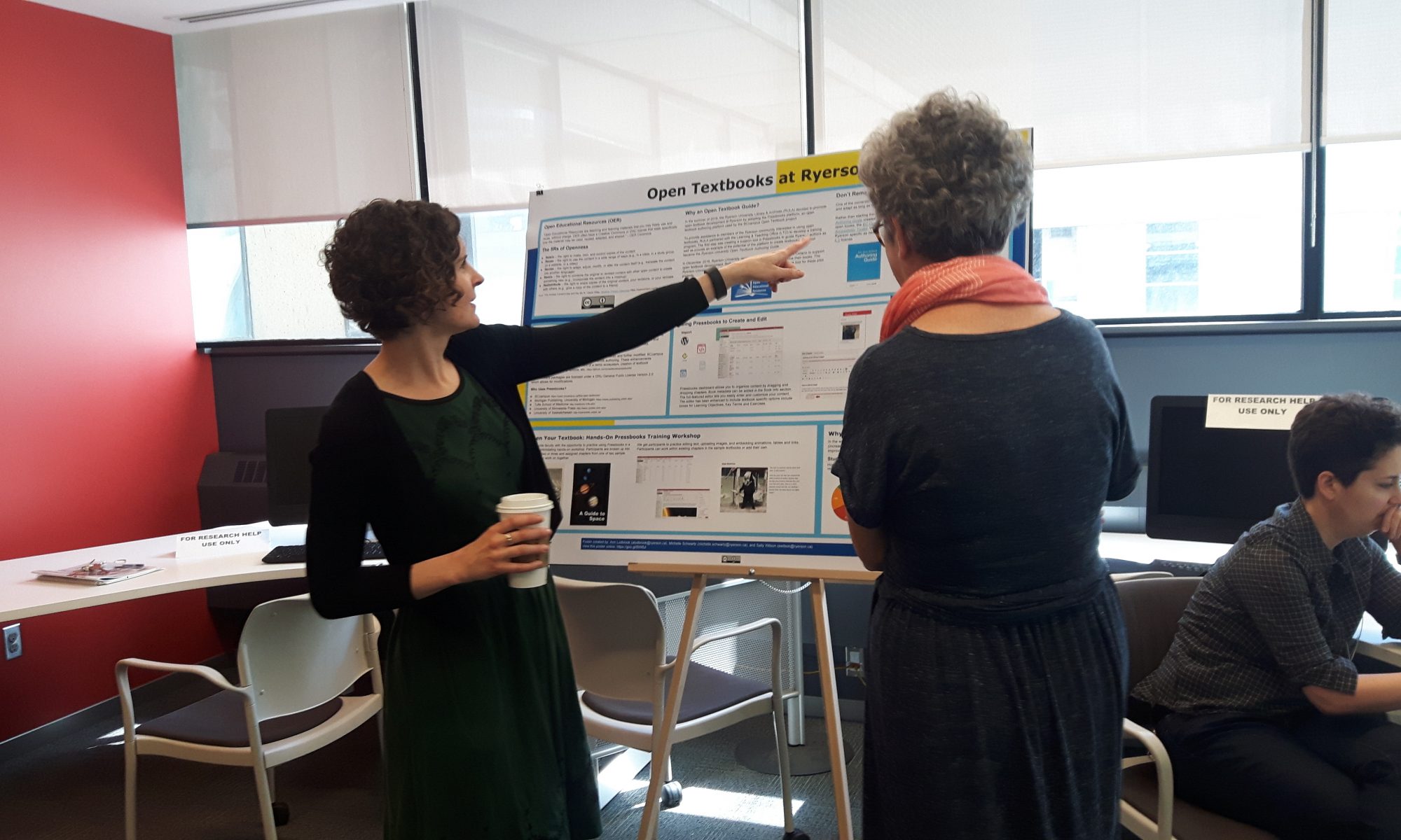 Two women looking at a poster presentation about Open Educational Resources and eCampusOntario