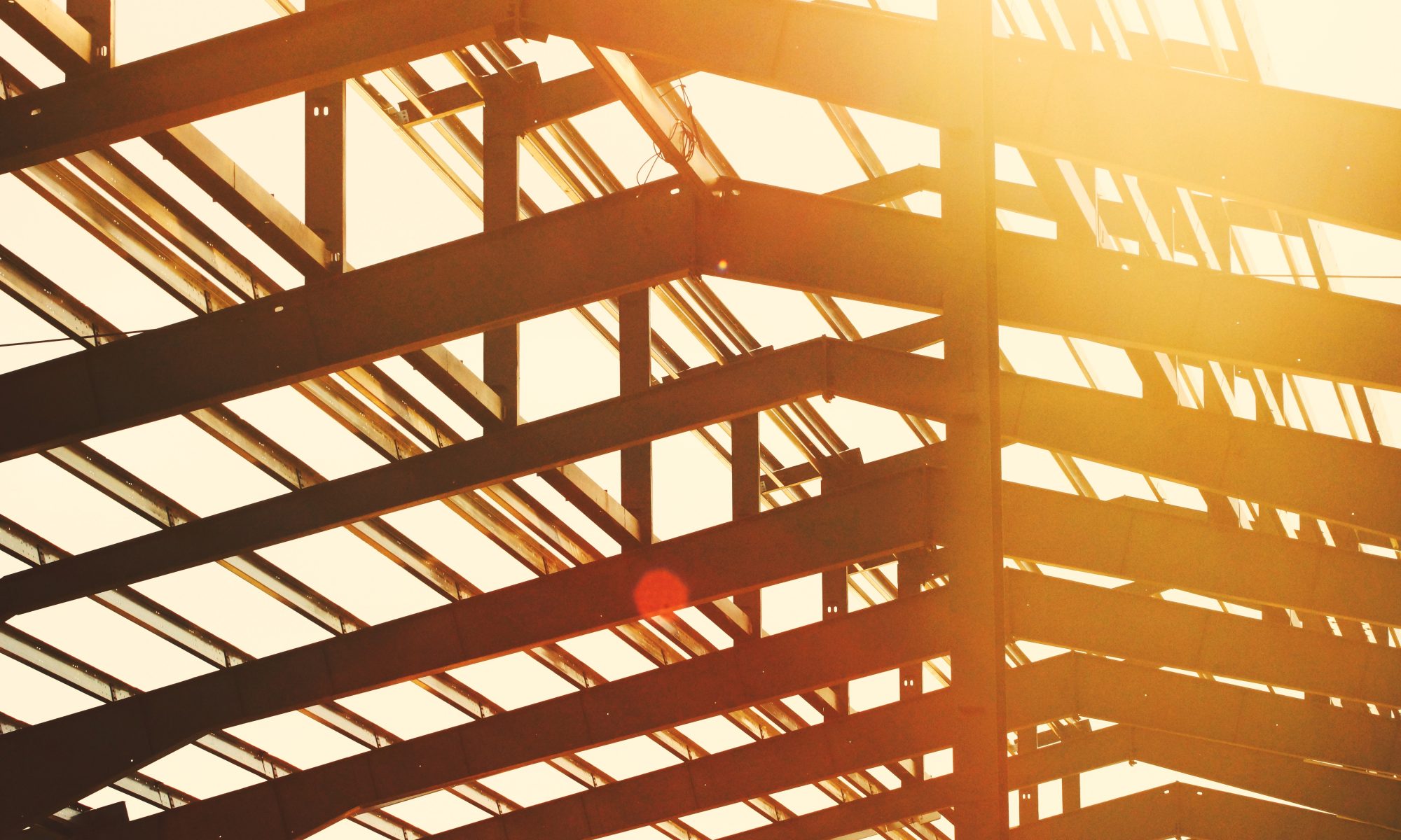 a construction site with sunlight streaming through the roof beams.